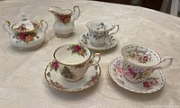 Photo showing the Old Country Roses sugar bowl, creamer, various teacups and saucers including April Brigadoon and Christmas Magic