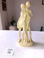Front view of the beige sculpture showing the male and female lovers embracing.