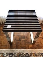 Front angled view of square table showing chrome base with mirrored side panels and dark wood slatted top.