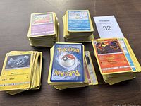 Top view of five piles of Pokemon cards arranged on a flat surface showing front and back of cards.