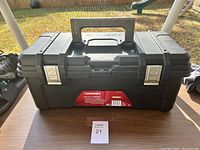 Front view of a black Husky toolbox showing the handle, metal latches, and front label with brand and details.