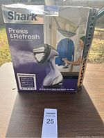 Photo of Shark Press & Refresh garment care system in original box, highlighting product branding and features.