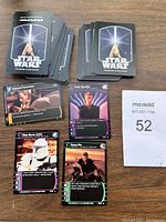 Two stacks of Star Wars trading cards, backs show Star Wars logo and lightsaber image.