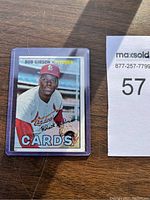 Full view of 1967 Bob Gibson baseball card in protective sleeve with partial background visible.