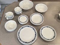Photo of Corelle dishes including large plates, medium plates, saucers, small bowls, cups, and serving bowls all with blue floral border