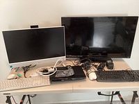 Overview photo showing the Dell monitor on the left, Vizio flat screen TV on the right, Philips Blu-Ray player in front center, two keyboards (one white, one black) and three mice on table along with various cables and remotes