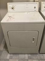 Front view of Kenmore electric clothes dryer, white, with closed door and dial control.
