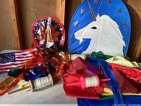 Both kites and spools with strings laid out showing unicorn kite and star kite with their tails and spools.
