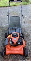 Photo of orange and black Husqvarna gas lawnmower with grass catcher bag showing condition and model identification