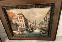 Oil painting showing a Venice canal scene with gondolas and classic buildings framed in dark wood