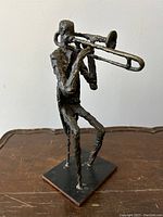 Front-left three-quarter view showing overall form, trombone detail, and textured surface.