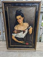 Full front view of painting and frame leaning against fence