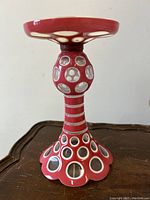 Close-up photo of the pink flashed Bohemian glass candleholder showing the honeycomb cutout design and flared base.