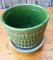 Front view of the green McCoy pottery planter showing embossed decorative pattern and matching saucer below.