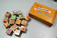 15 wooden puzzle blocks with vintage Goldilocks the Three Bears illustrations, some scattered next to original box showing colorful printed lid