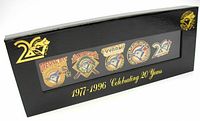 Front view of the boxed set with five commemorative Toronto Blue Jays pins displayed behind a clear cover. The black box features gold Blue Jays logos and text stating '1977-1996 Celebrating 20 Years'.