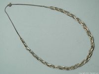 Full view of the silver chain necklace laid flat to show entire length and design details.