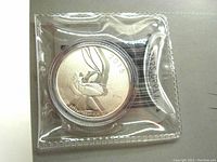 Photo of the 2015 fine silver Bugs Bunny coin in sealed plastic sleeve.