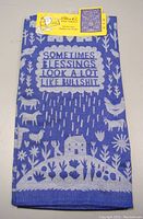Front view of jacquard tea towel folded with humorous text and animal/farm motifs in blue and white.