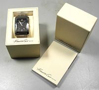 Full view of Kenneth Cole men's watch in original ivory packaging box with lid and outer box showing branding.