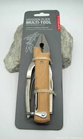 Front view of new Kikkerland Wooden Plier Multi-Tool attached to original card, showing wooden handle and metal tools folded inside.