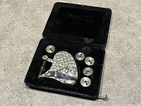 Velvet-lined box open showing the main drafting pen and six spare cam wheels