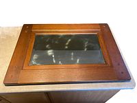 Front view of the antique oak framed mirror showing wood grain, riveted corners, and reflective glass.