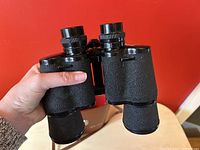 Carl Wetzlar binoculars held in hand, showing textured body and eyepieces.
