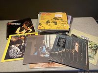 Group photo of vinyl record albums showing cover artwork including Steve Miller Band, Bee Gees, Roberta Flack, Carole King, Neil Diamond, and more.
