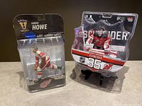 Two hockey figure collectibles together: Gordie Howe figure (box opened and taped) and Schneider goalie figure (sealed)