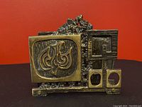 Front view of vintage brass metal napkin holder showing abstract brutalist design details.