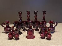 Full view of the entire 20-piece set arranged on a counter, showing all items including candleholder bottles, shakers, cups, oil/vinegar bottles, and bell.