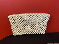 Front view of the vintage white bead clutch bag showing full bead coverage and zipper closure.