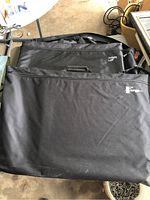 Two large black canvas art folder bags stacked, one branded Artists Loft and the other Electric.