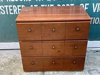 Front view of the wooden dresser showing all three drawers closed with metal handles.