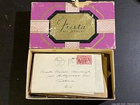 Closed box with purple and gold Fiesta Assortment label containing assorted stamps and envelopes.
