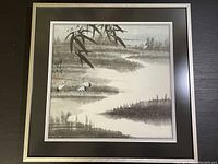 Overall view of the framed artwork showing a calm river scene with cranes and bamboo leaves