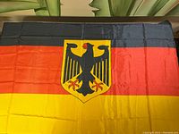Full view of the vintage German flag with black, red, and gold stripes and central eagle shield.