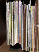 Side view of a collection of vintage LP vinyl records tightly packed vertically showing aged, worn sleeves.