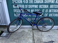 Side view of vintage Miyata bicycle showing blue frame, saddle, tires, and handlebar.