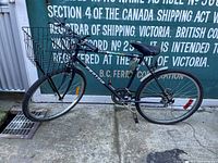 Side view of black Protour bicycle with front basket and reflectors.