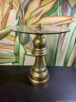 Side view of the round glass top on the brass base end table, showing the design and scale.