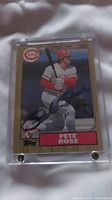 Front of 1987 Topps Pete Rose baseball card showing player in batting stance and autograph.