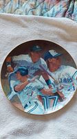 Full image of the round Toronto Blue Jays collector plate showing three players in action poses, detailed team uniforms, and logo.