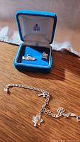 Photo showing bracelet with charms and jewelry box on wood surface