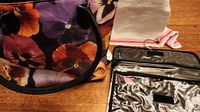 Photo showing large pansy print bag with black trim and colorful floral pattern.
