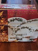 Original box showing 47 piece fine china dinner set for 8 with Christmas holly and gold bow decoration