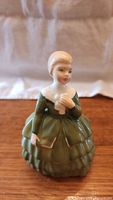 Front view showing Belle in tiered green dress holding white dove.
