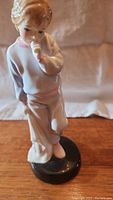 Front angle of the Sleepy Darling Royal Doulton porcelain figurine showing the boy's face and pose.