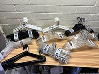 Assorted hangers grouped and bundled on a table with labels showing quantities.